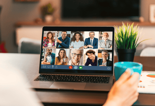 A laptop screen displaying focus group participants in a video call,  representing the debate between recruiting participants for research online or face to face.