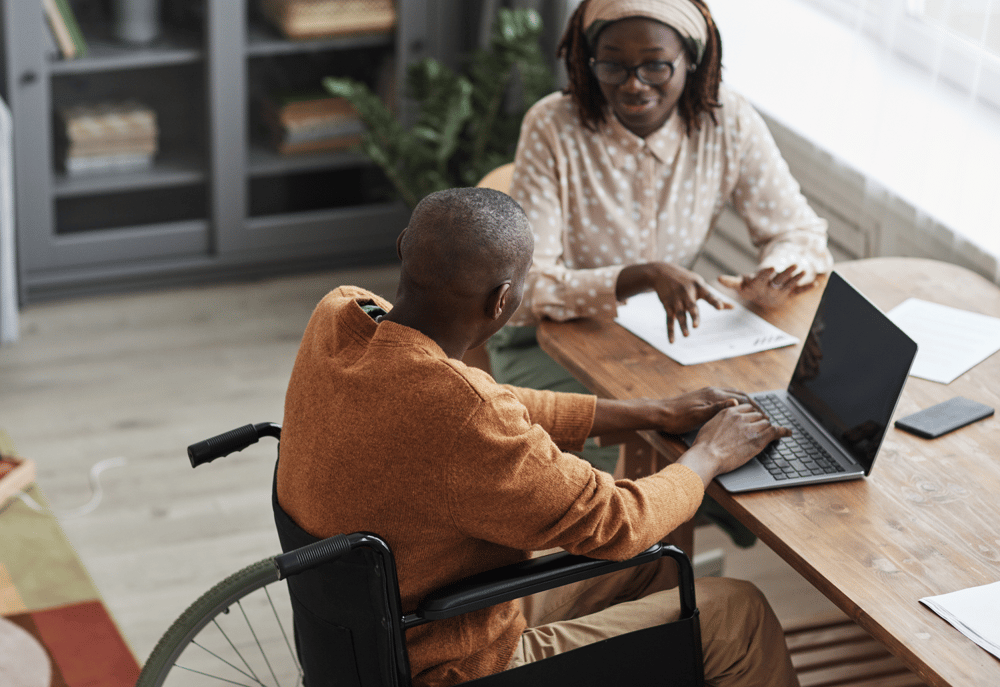 A market researcher completing a screener with a disabled participant, representing ways of making research accessible.