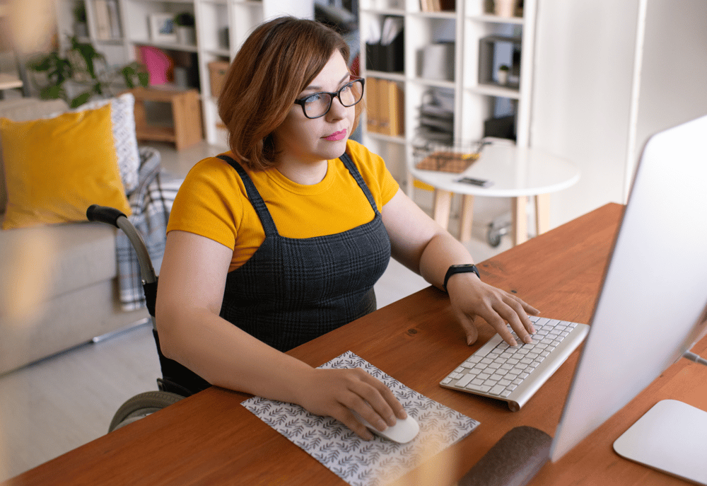 A wheelchair user filling out a consent form on her computer as part of  participant recruitment in qualitative research.  