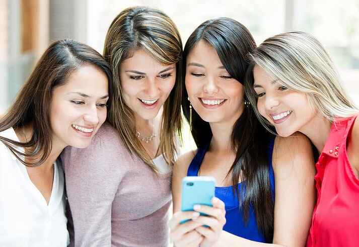 Group of girls looking at a cell phone-1