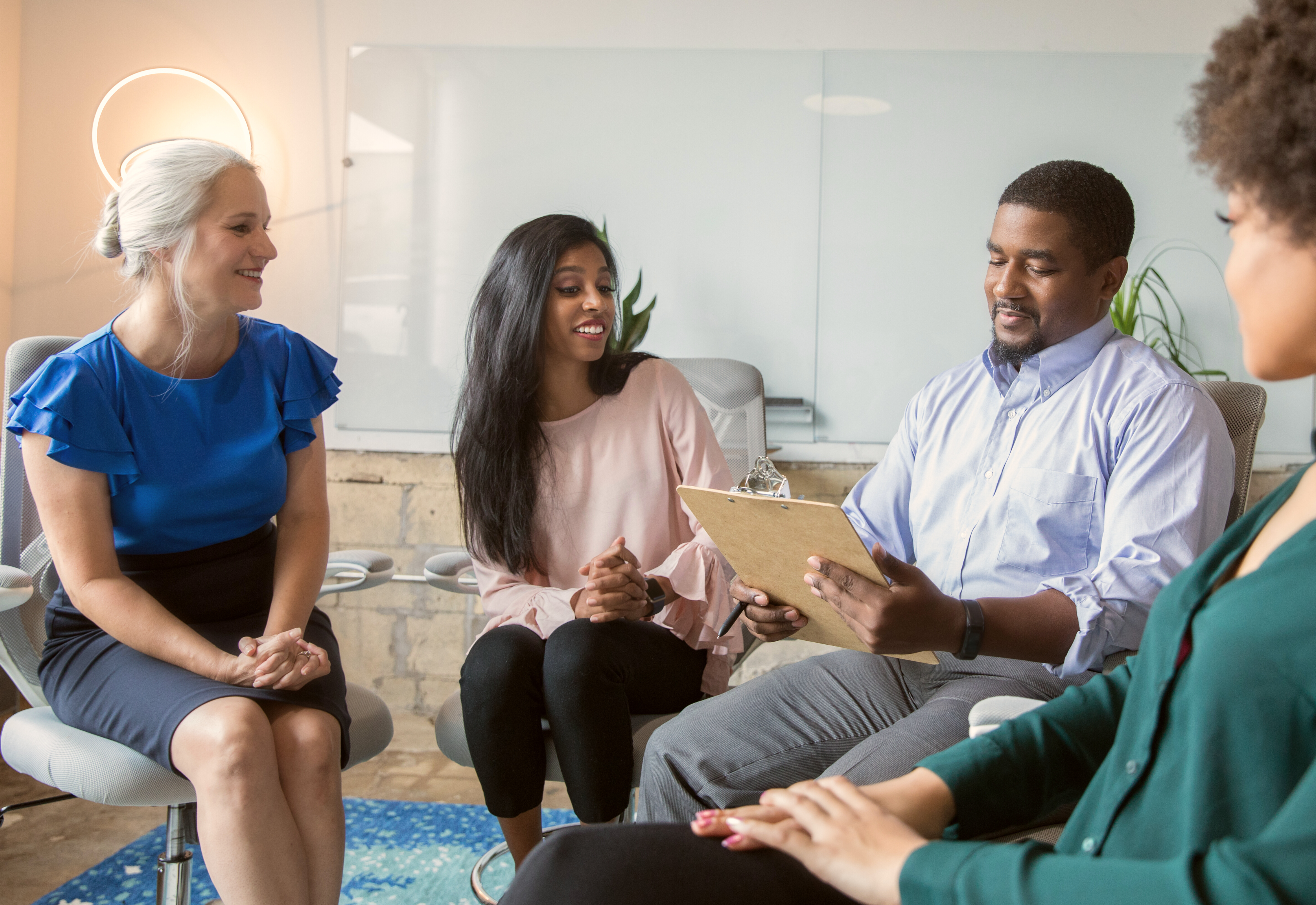 Research participants sat in a circle with a moderator in a focus group.