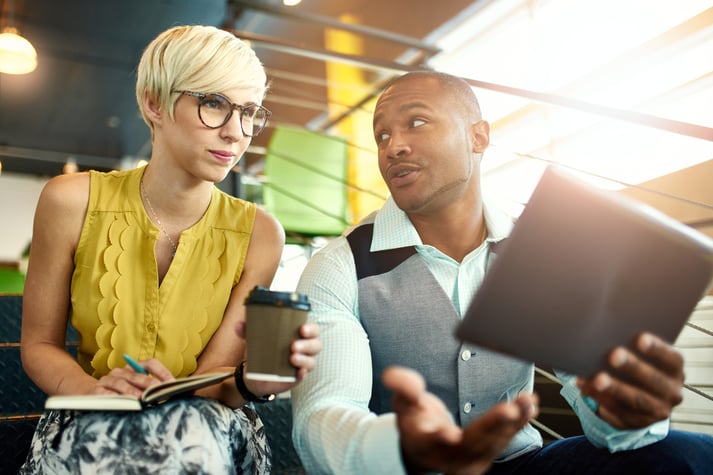 Two market researchers discussing recruiting research participants through social media