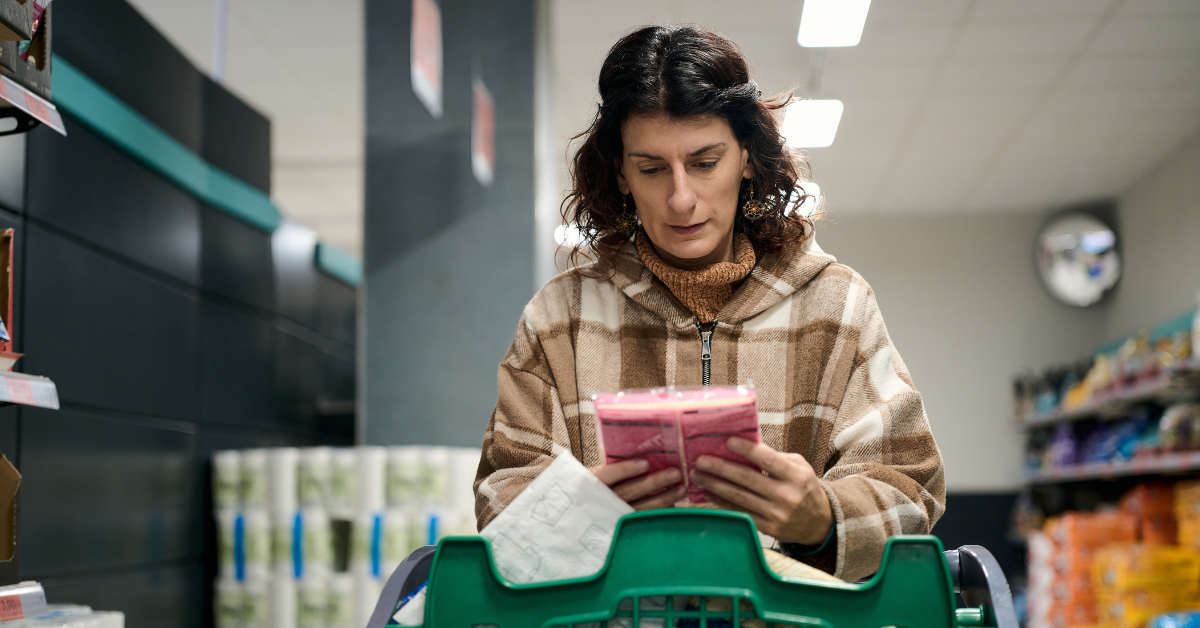 •	Shopper scrutinising food product ingredient label in a grocery store