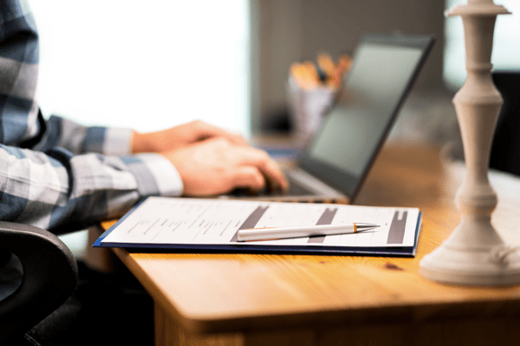 User research recruitment agency team member creating a screener on a laptop and clipboard.png