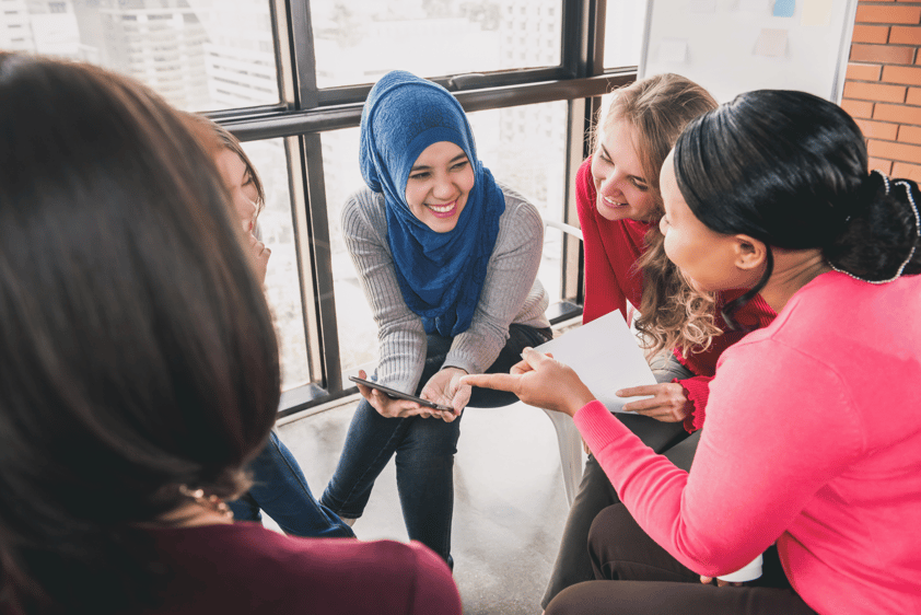 Women sitting in circle enjoying sharing stories in group meeting, representing storytelling in market research