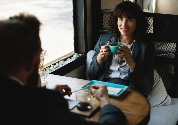 2 people having a meeting whilst drinking coffee