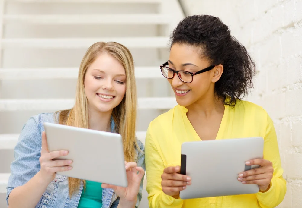 Two women comparing MROC proposals on tablets