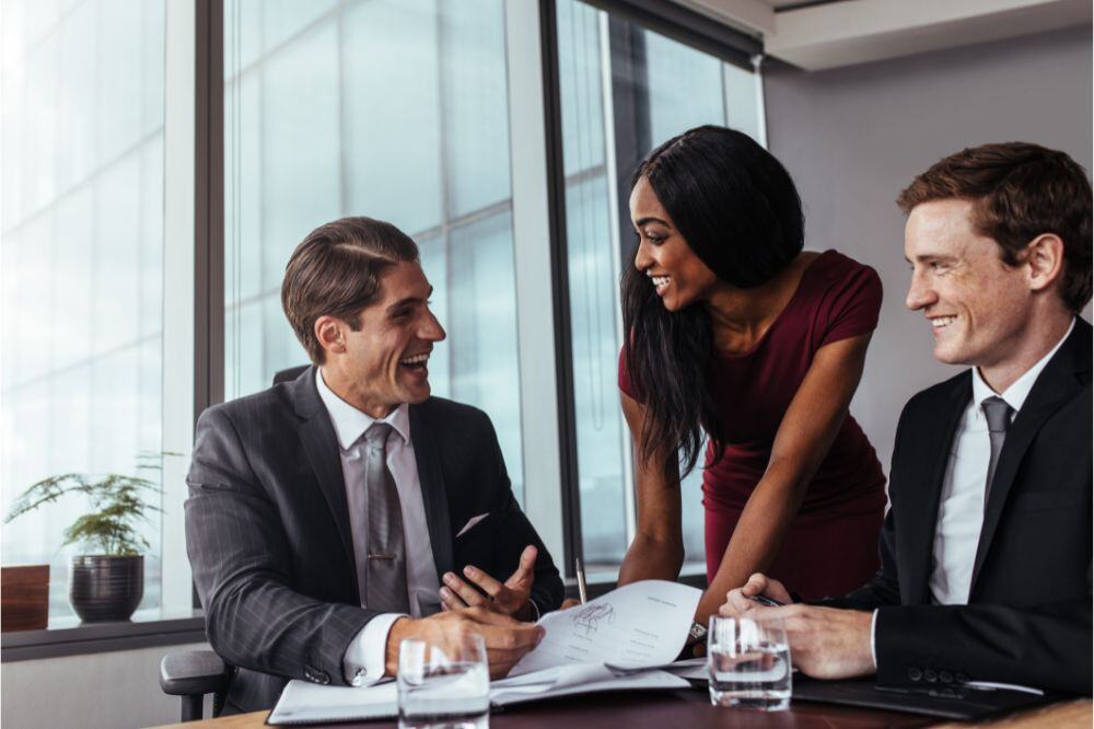 three people at a table, representing market research trends