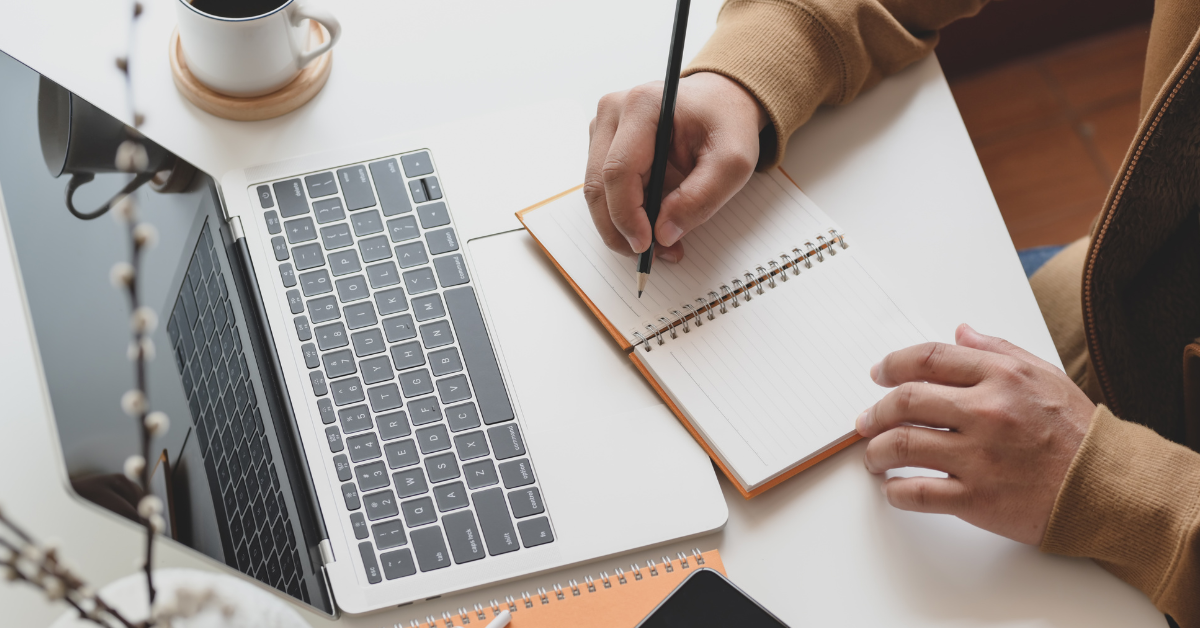 person writing market research screener in notebook