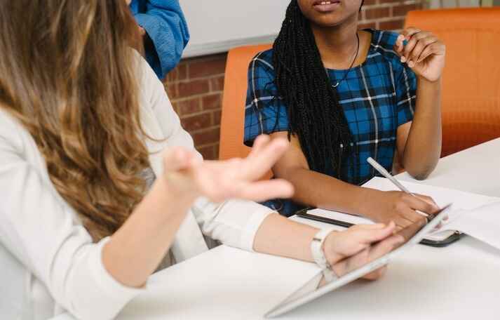 a women with a tablet talking to other people, represeting how to recruit for ux research