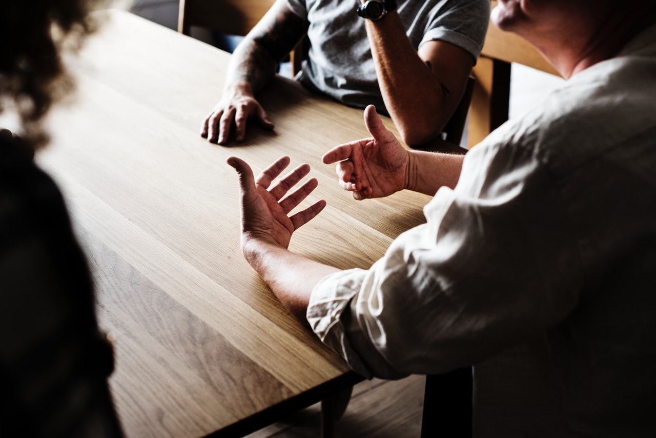 Research participants sat at a table with a moderator in a focus group.