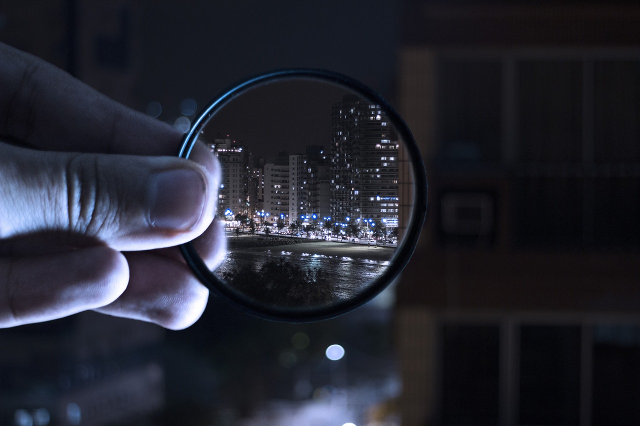 Magnifying glass looking through a city scape to represent social grades in market research