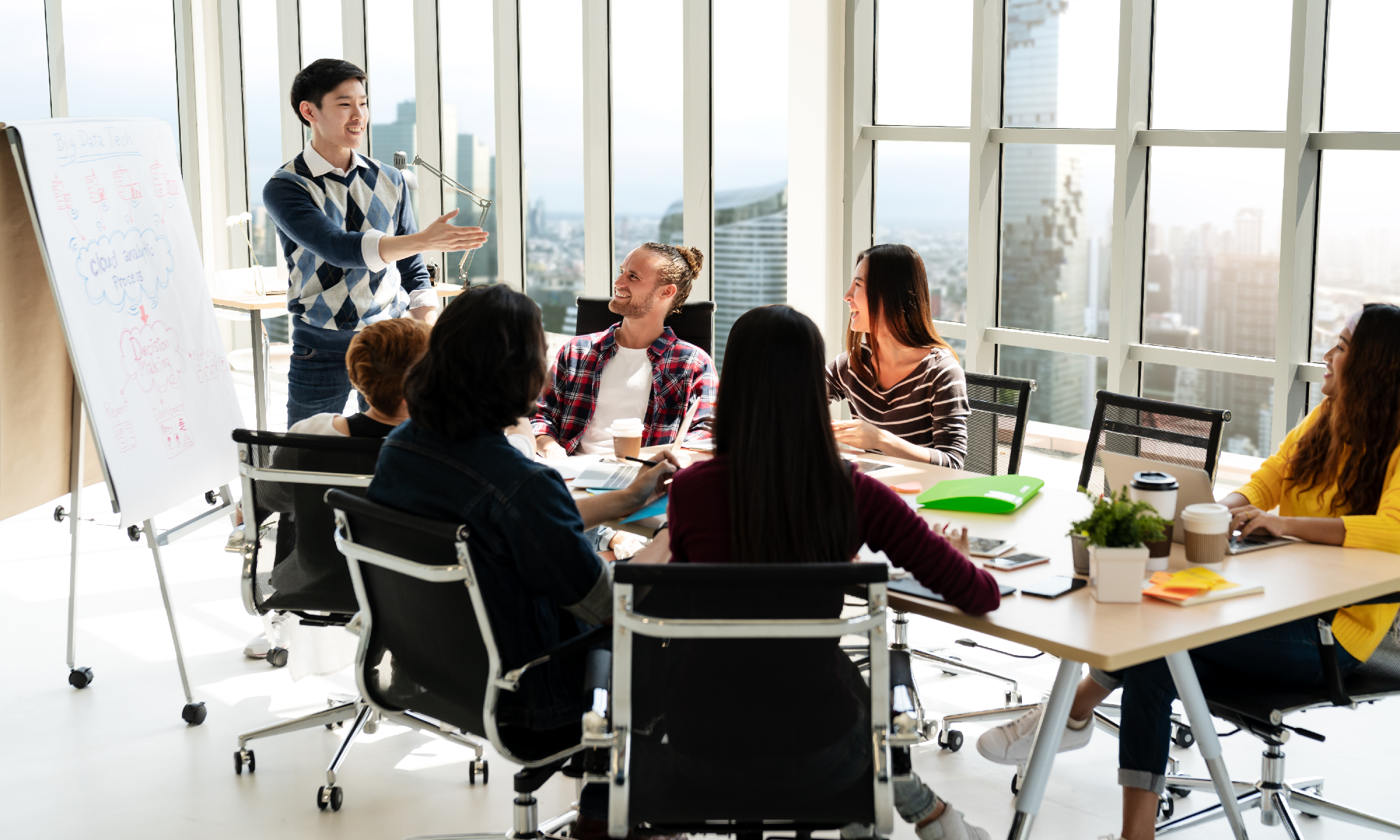 Group of market researchers around a conference room table discussing why to do a design sprint